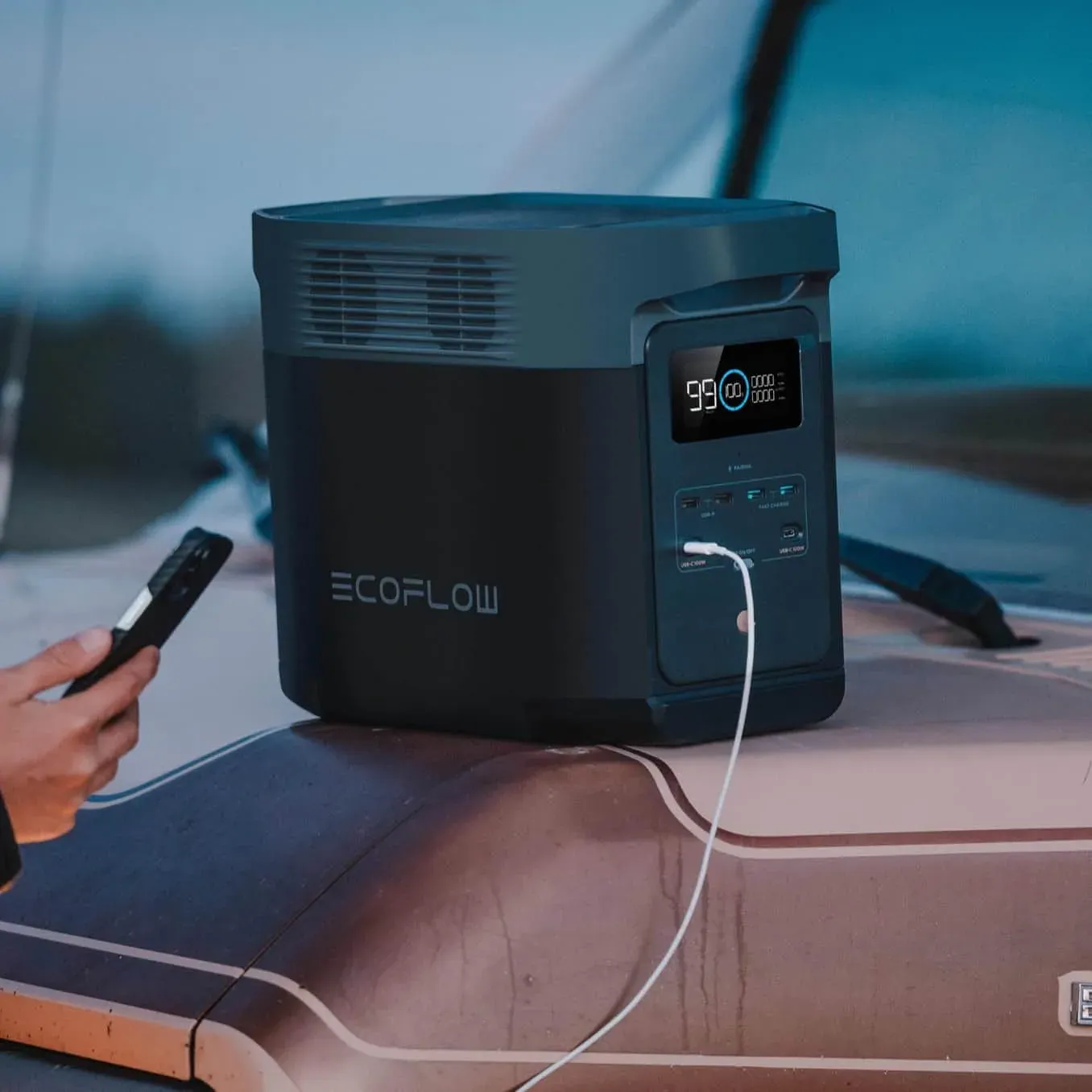La DELTA 2 posée sur le toit d'un van au crépuscule, un téléphone branché en USB-C
